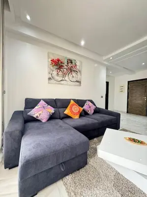 a living room with a blue couch with colorful pillows at Front of beach apartment marina yakht 2 in Casablanca