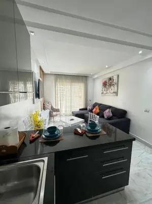 a kitchen with a sink and a living room at Front of beach apartment marina yakht 2 in Casablanca