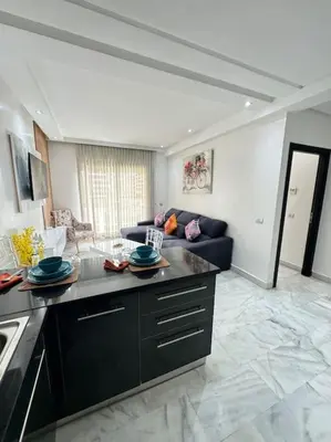 a kitchen and living room with a couch in a room at Front of beach apartment marina yakht 2 in Casablanca