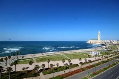 a view of the beach and the ocean with a lighthouse at Front of beach apartment marina yakht 2 in Casablanca