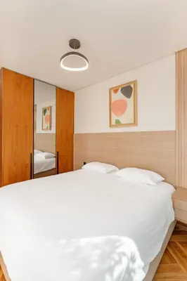 a bedroom with a white bed and a mirror at Harmony Garden in Casablanca