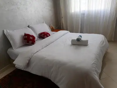 a white bed with a bottle of water on it at Omarex in Casablanca
