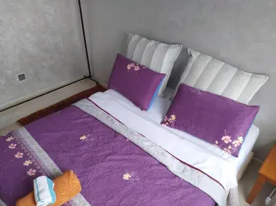 a bed with purple and white sheets and pillows at Omarex in Casablanca