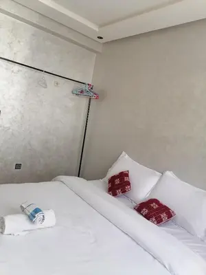 a bedroom with two white beds with red pillows at Omarex in Casablanca