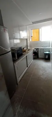 a kitchen with white appliances and a large window at Appart RABAT AGDAL in Rabat