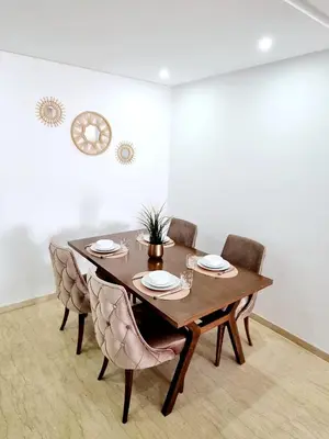 a dining room with a wooden table and chairs at Appartement spacieux au cœur du Parc Proche plage Entre Casa et Rabat in Mohammedia