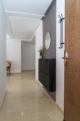 a hallway with a mirror on the wall and a door at Appartement spacieux au cœur du Parc Proche plage Entre Casa et Rabat in Mohammedia