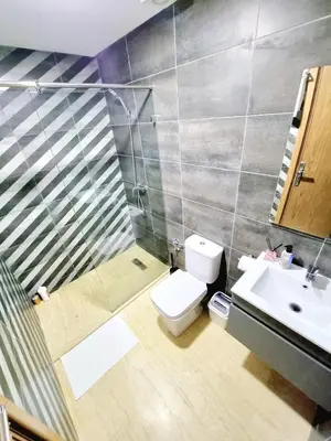 a bathroom with a shower and a toilet and a sink at Appartement spacieux au cœur du Parc Proche plage Entre Casa et Rabat in Mohammedia