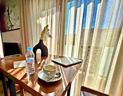 a table with a cup of coffee and a bottle of water at AS Premium By Soho Hotels Maarif in Casablanca