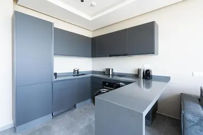a kitchen with black cabinets and a counter top at Atlantic View Appart'Hotel in Casablanca