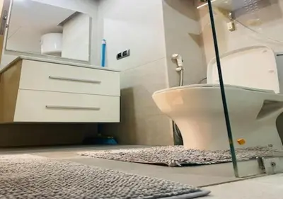 a bathroom with a sink and a toilet and a rug at Bel Appartement Cosy dans le centre de Casablanca in Casablanca