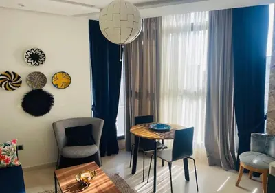 a living room with a dining room table and chairs at Bel Appartement Cosy dans le centre de Casablanca in Casablanca