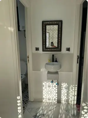 a white bathroom with a sink and a mirror at Chambre à Agdal Rabat dans un appartement partagé -two single beds- in Rabat