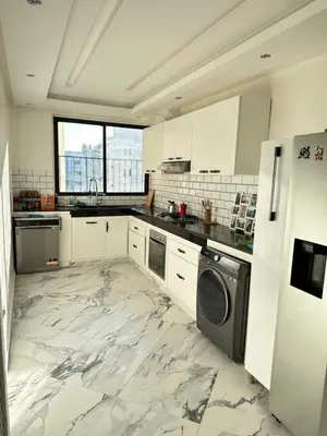 a kitchen with white cabinets and a marble floor at Chambre à Agdal Rabat dans un appartement partagé -two single beds- in Rabat
