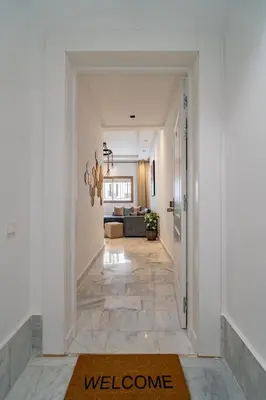 a hallway leading to a living room with a welcome rug at AeroStudio in Nouaceur