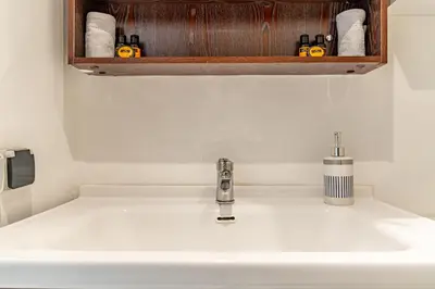 a white sink in a bathroom with aabinet above it at AeroStudio in Nouaceur