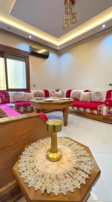 a living room with a couch and a table at Classic & Comfy Apartment, Steps to Sea & Tarmway in Rabat