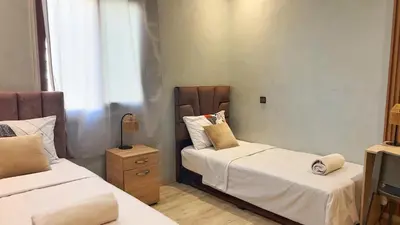 a bedroom with two beds and a night stand at Classic & Comfy Apartment, Steps to Sea & Tarmway in Rabat