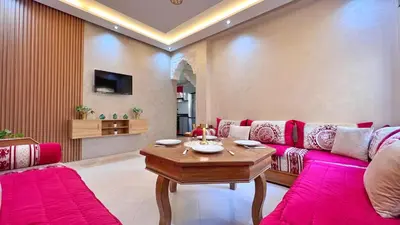 a living room with pink couches and a table at Classic & Comfy Apartment, Steps to Sea & Tarmway in Rabat