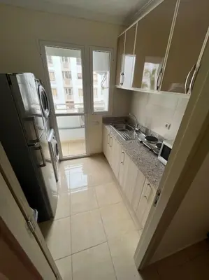 a small kitchen with a refrigerator and a sink at Appartement Sidi Rahal in Sidi Rahal
