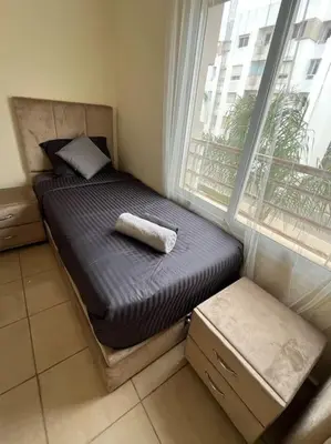a small bed in a room with a window at Appartement Sidi Rahal in Sidi Rahal