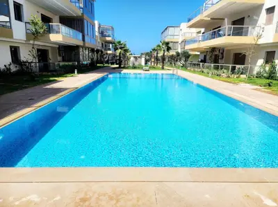 a large blue swimming pool in front of a building at Bleu Beach Résidence, Sidi Rahal in Sidi Rahal