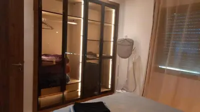 a bedroom with a closet with a glass door at Bleu Beach Résidence, Sidi Rahal in Sidi Rahal