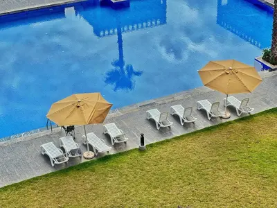 an overhead view of a pool with chairs and umbrellas at Séjour Chic - Appartement Moderne avec Piscine in Bouznika