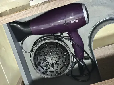 a purple hair dryer sitting on top of a shelf at Séjour Chic - Appartement Moderne avec Piscine in Bouznika
