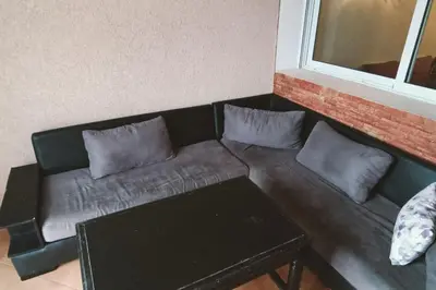 a black couch with pillows in a living room at Sun Palace Palage des Sablettes D5 in Mohammedia