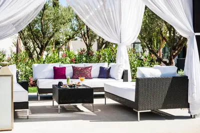 a patio with a couch and chairs and curtains at STORY Rabat in Rabat