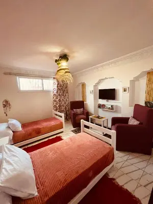 a bedroom with two beds and a living room at Enchanting Studio in Casablanca in Casablanca