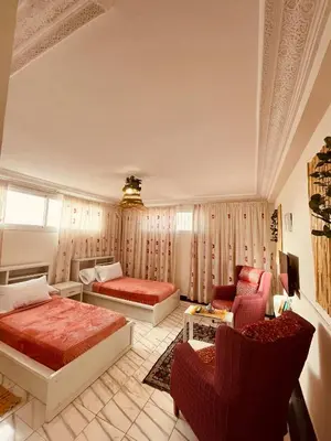 a bedroom with a bed and a couch and chairs at Enchanting Studio in Casablanca in Casablanca