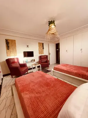 a bedroom with two beds and a living room at Enchanting Studio in Casablanca in Casablanca