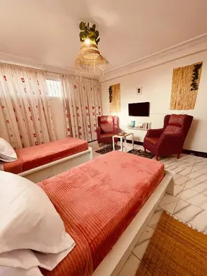 a bedroom with two beds and a living room at Enchanting Studio in Casablanca in Casablanca