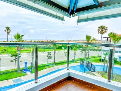 a balcony with a view of a pool and palm trees at Premium Appartement vue panoramique mer et piscine in Casablanca
