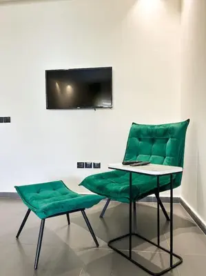 two green chairs and a table with a laptop on it at Premium Appartement vue panoramique mer et piscine in Casablanca
