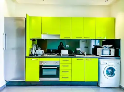 a kitchen with bright green cabinets and a washer at Premium Appartement vue panoramique mer et piscine in Casablanca