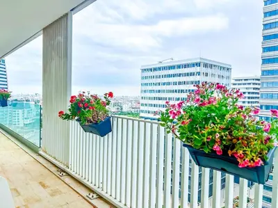 three flowerpots on a balcony with flowers in them at Appartement prestige vue dégagée in Casablanca