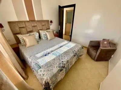 a bedroom with a large bed and a chair at Sweet Home in Casablanca