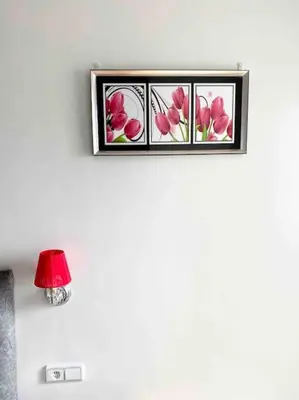 a picture frame with three pink flowers on a wall at Sweet Home in Casablanca
