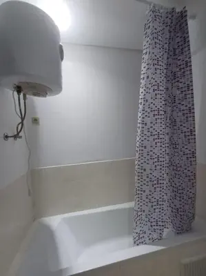 a bathroom with a shower curtain and a light at Appartement Sidi Rahal à Garden beach2 in Sidi Rahal