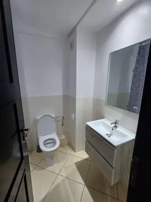 a bathroom with a white toilet and a sink at Appartement Sidi Rahal à Garden beach2 in Sidi Rahal