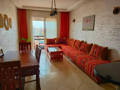 a living room with a couch and a table at Appartement Sidi Rahal à Garden beach2 in Sidi Rahal