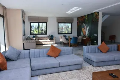 a living room with two blue couches and a table at Bens White House in AÃ¯n el Ksob