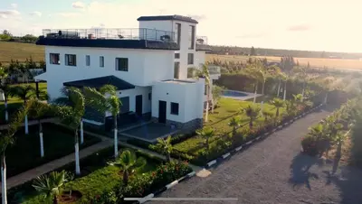 an aerial view of a white house with palm trees at Bens White House in AÃ¯n el Ksob