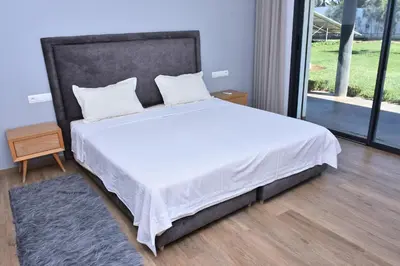 a bed with white sheets and pillows in a bedroom at Bens White House in AÃ¯n el Ksob