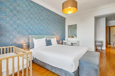 a bedroom with a large bed and a crib at Spacious 2 Bed Flat with City Views and Free Parking in Casablanca