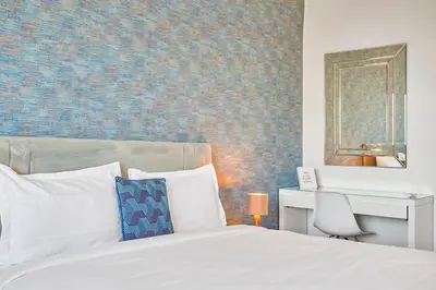 a bedroom with a bed and a desk and a mirror at Spacious 2 Bed Flat with City Views and Free Parking in Casablanca