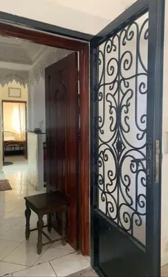 an open door to a room with a table next to it at Adorable Apartamento a 8 Min del Aeropuerto de Casablanca,WiFi Ultra Rapido y Parking Gratis in Derroua